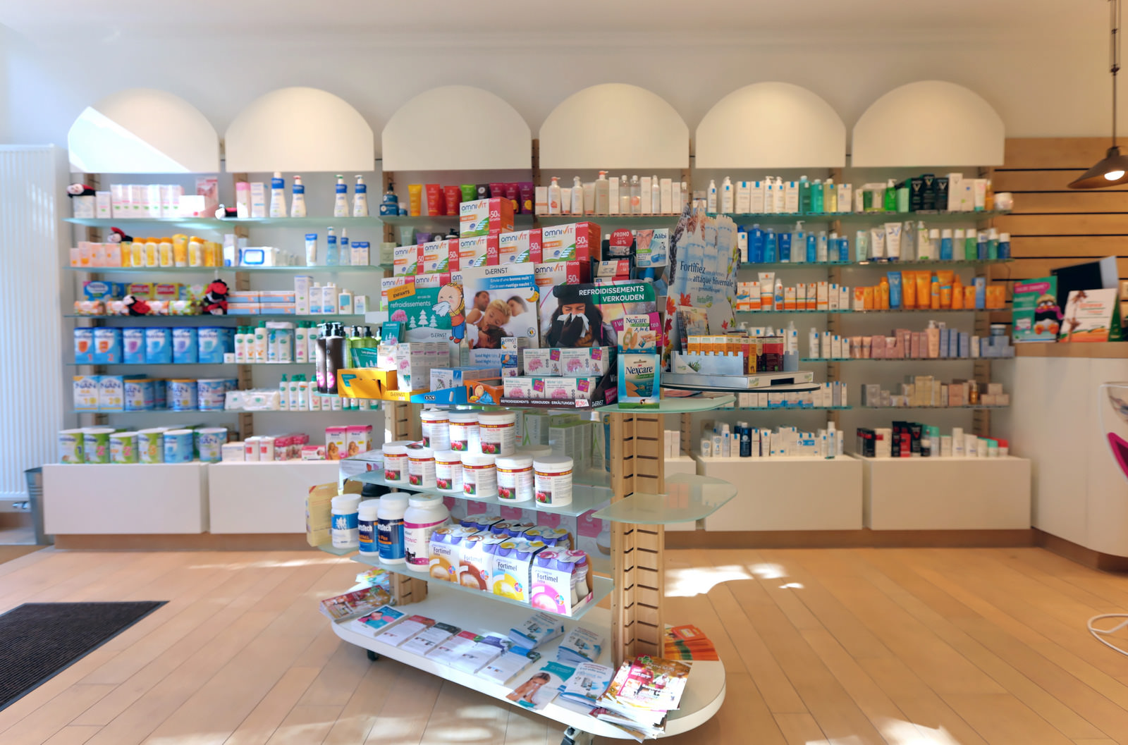 Rayons de la pharmacie avec produits dermo-cosmétiques et compléments alimentaires.