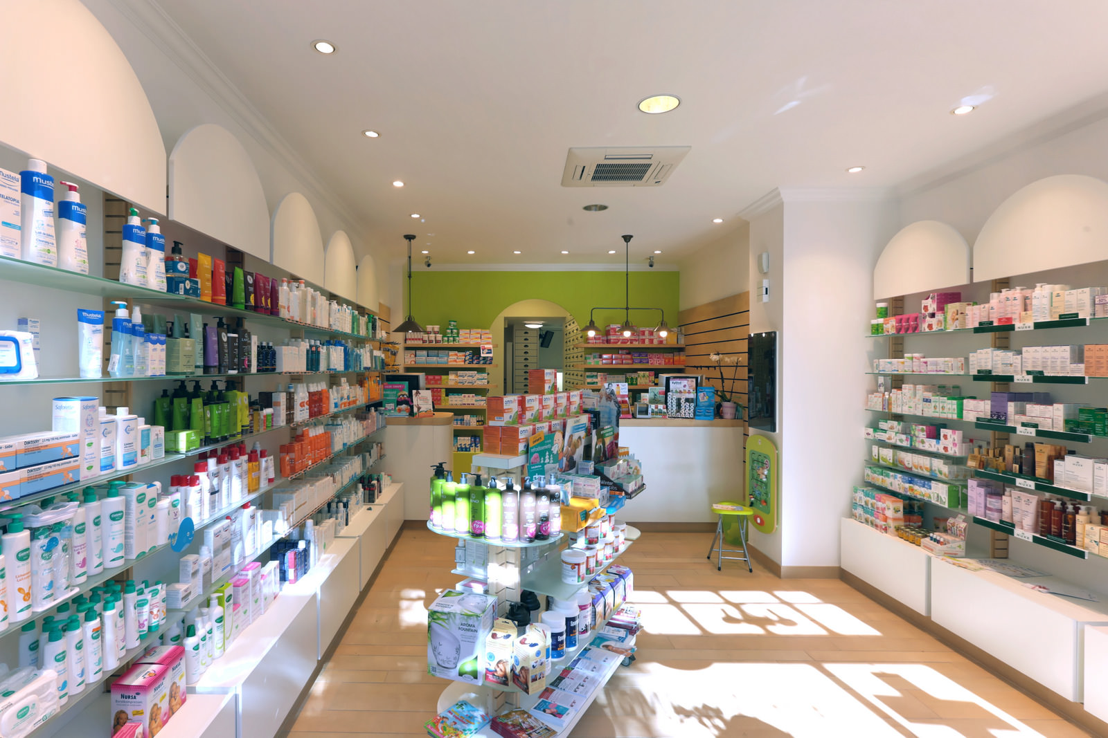 Vue intérieure de la Pharmacie Mory : rayons clairs, sol en bois, lumière naturelle.